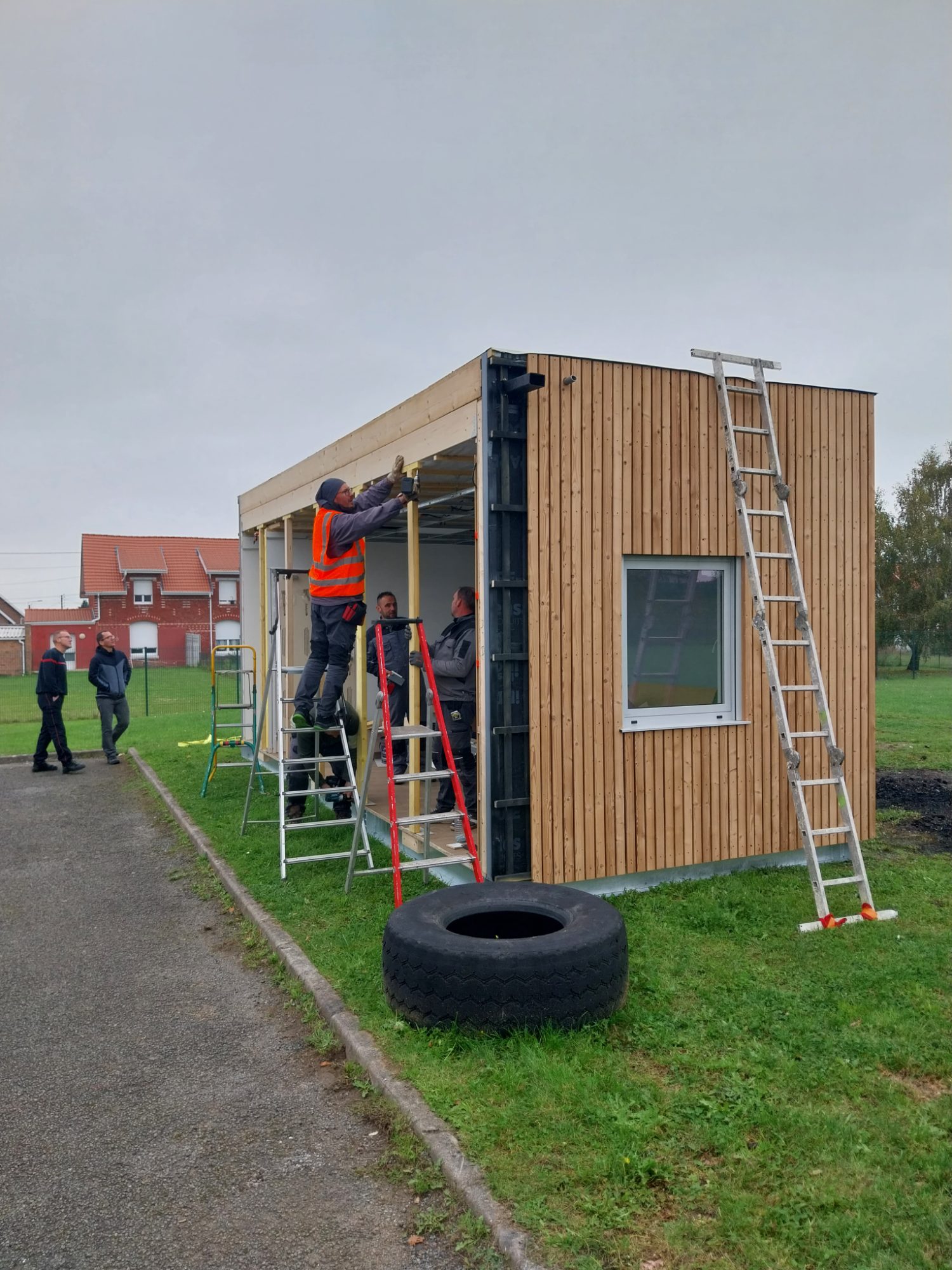 Module à ossature bois bardé de bois en cours de pose sur site