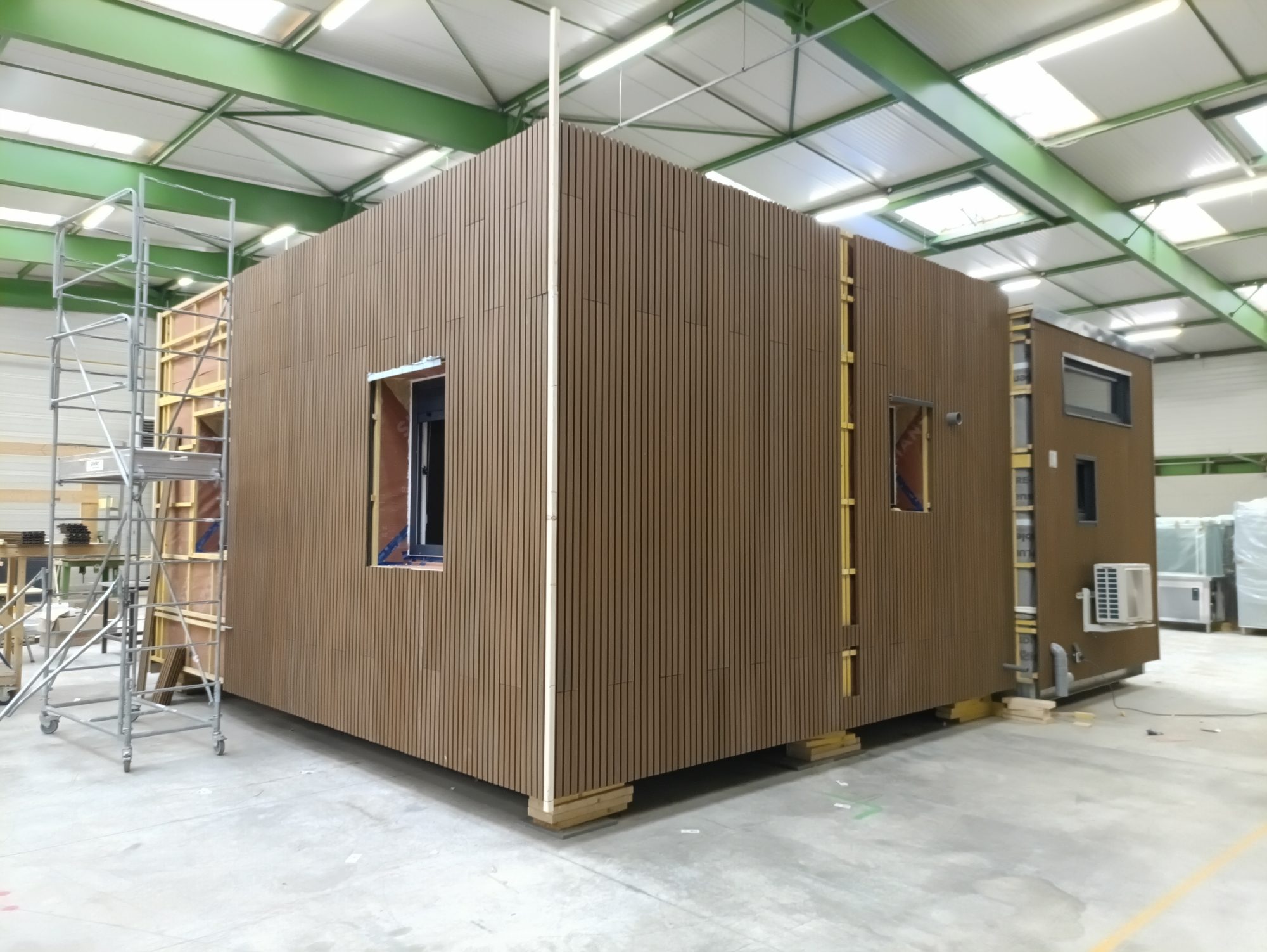 Module container reconditionné à finition bois et large baie vitrée, en atelier