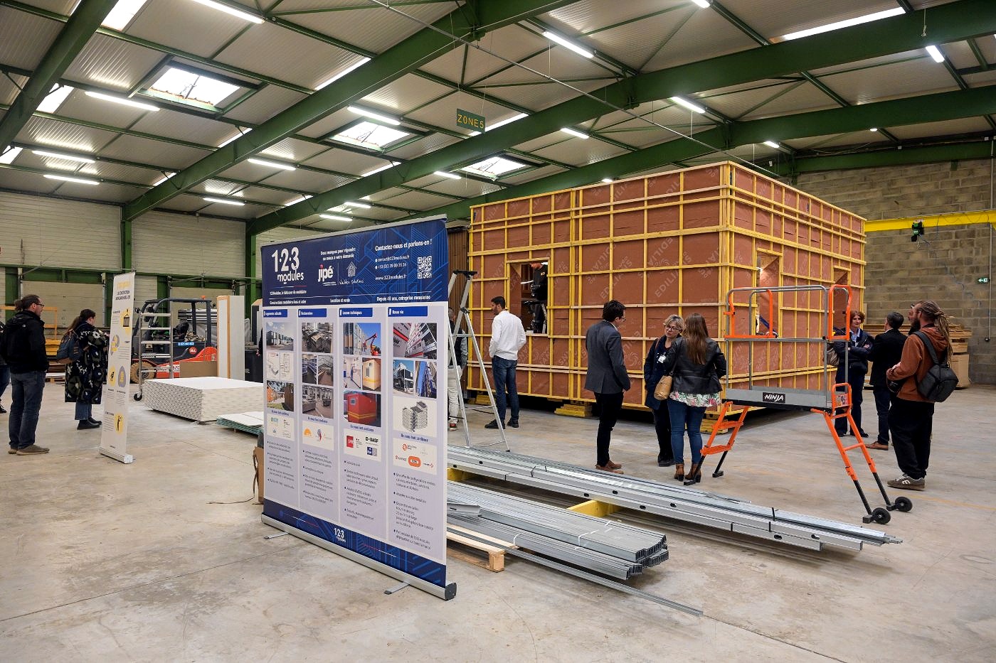 Apprenants en sweat Forma Cargo posant réseaux et rails à l'intérieur du démonstrateur