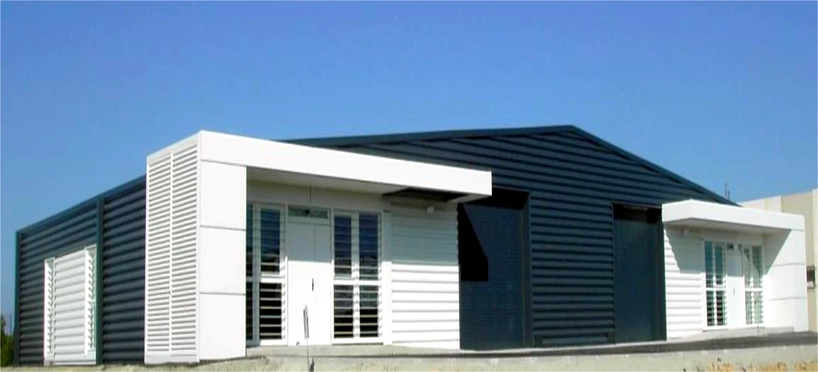 Bureaux et entrepôt modulaires DGA — vue d'ensemble, bardage blanc et anthracite