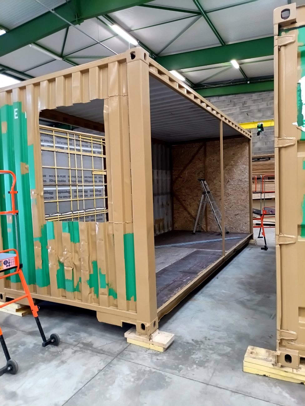 Container reconditionné ouvert en atelier, doublage intérieur en panneaux OSB en cours d'installation