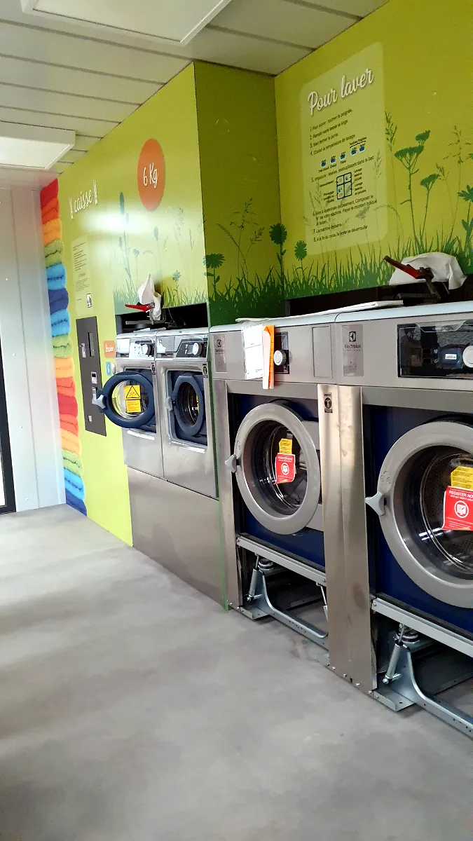 Intérieur équipé de machines Electrolux et décor mural — Lux Laverie