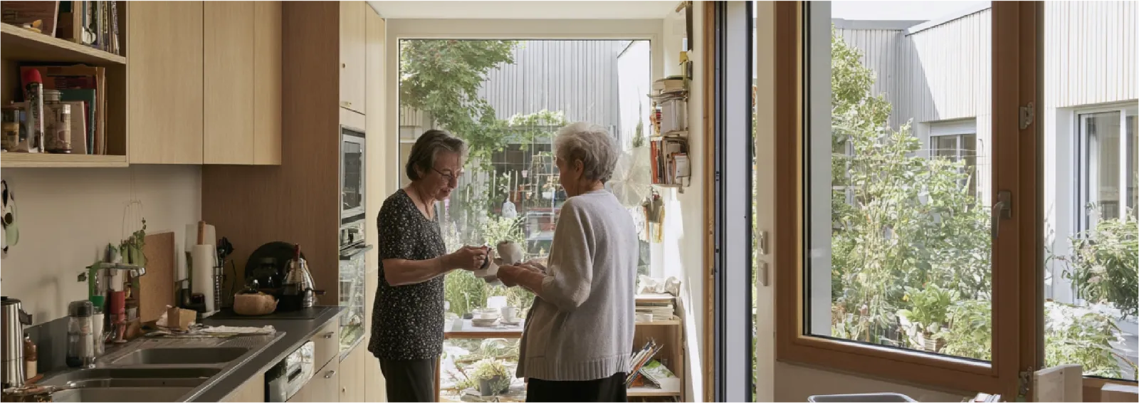 Cuisine lumineuse d'un logement senior ouverte sur le jardin